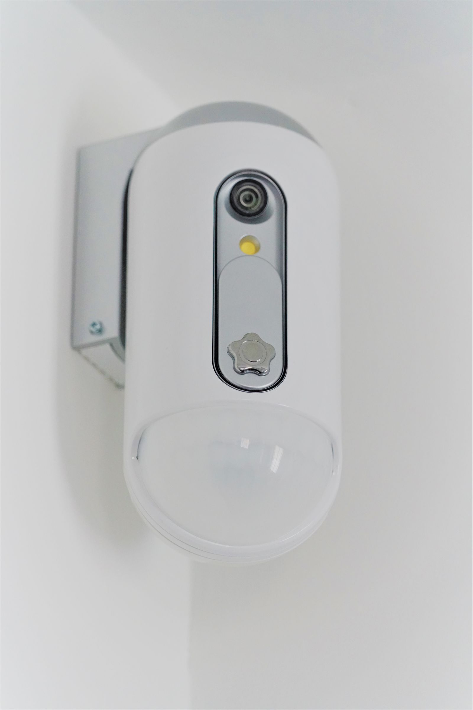 A surveillance camera mounted high on a wall inside a shop