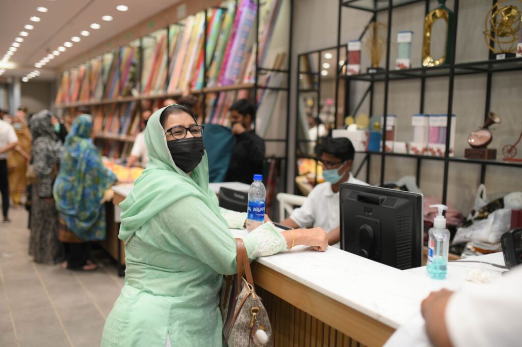 A cashier serving a customer at a shop checkout counter
