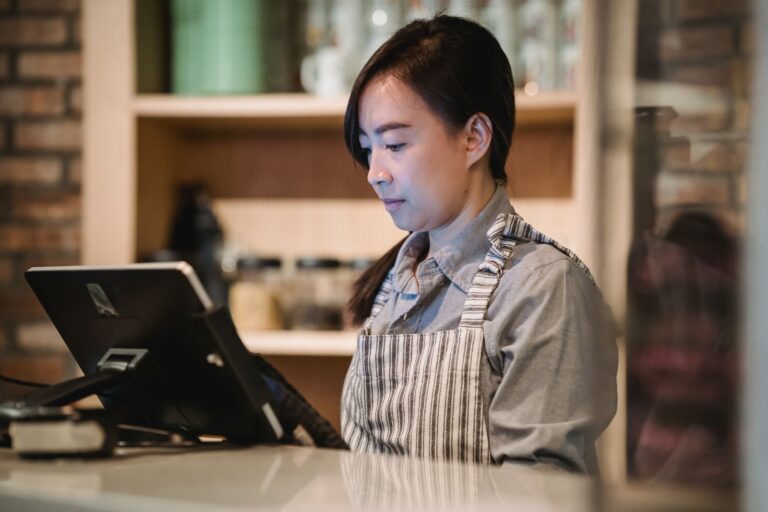 A retail worker at a checkout till during a day of store sales