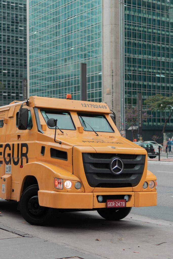A yellow armoured truck on a city street during a cash collection round
