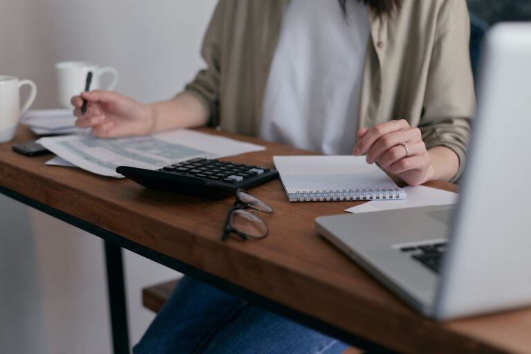 A small business owner reviewing invoices and cash flow figures at a desk