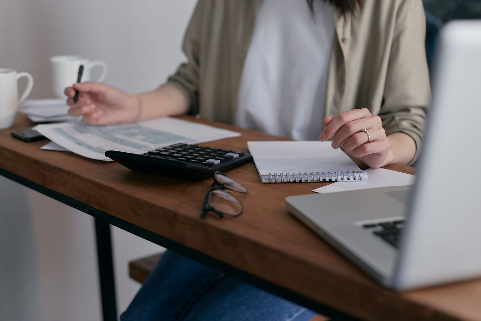 A small business owner reviewing invoices and cash flow figures at a desk