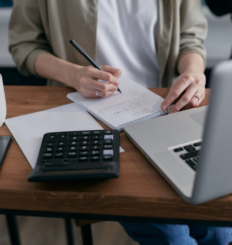 A laptop and calculator being used to work through a cash flow forecast