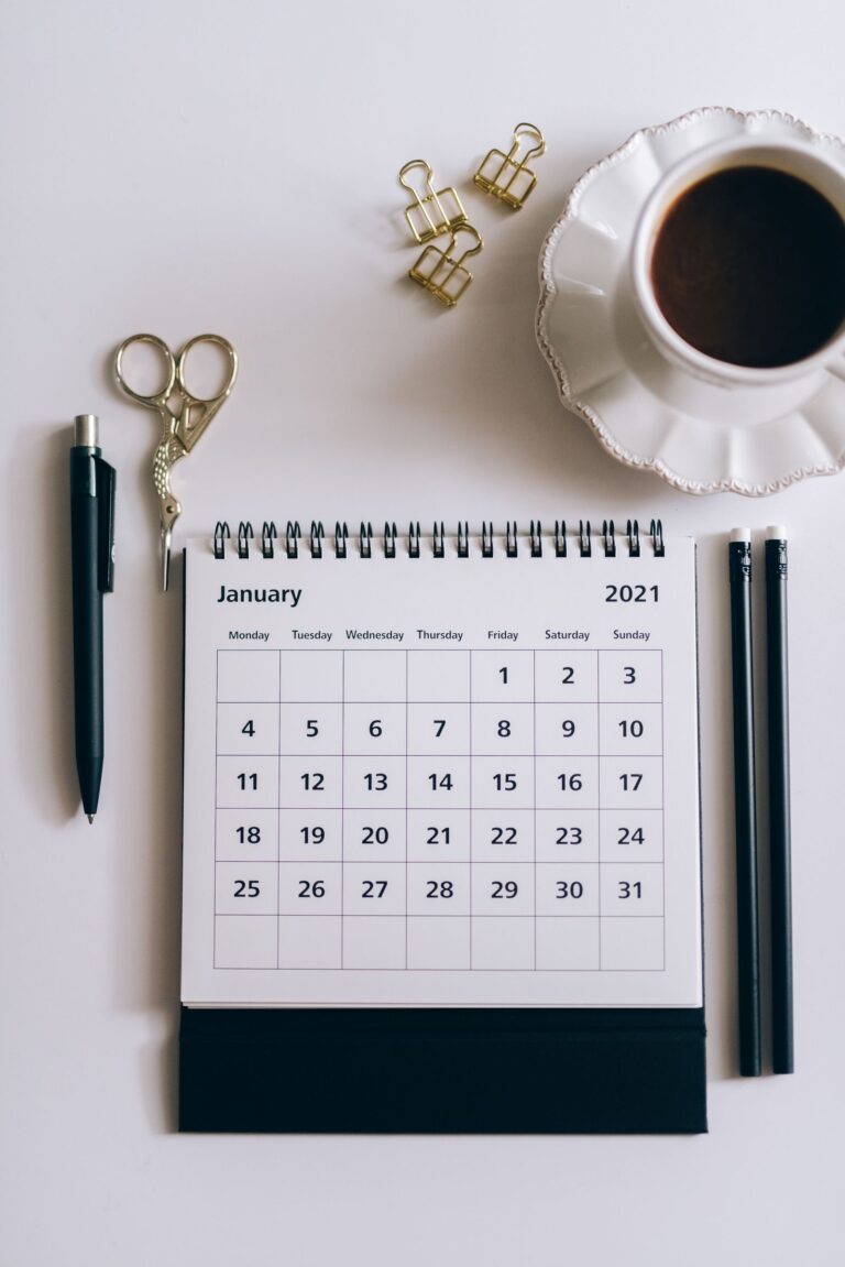 A notebook and calendar laid out for an annual small business financial planning session