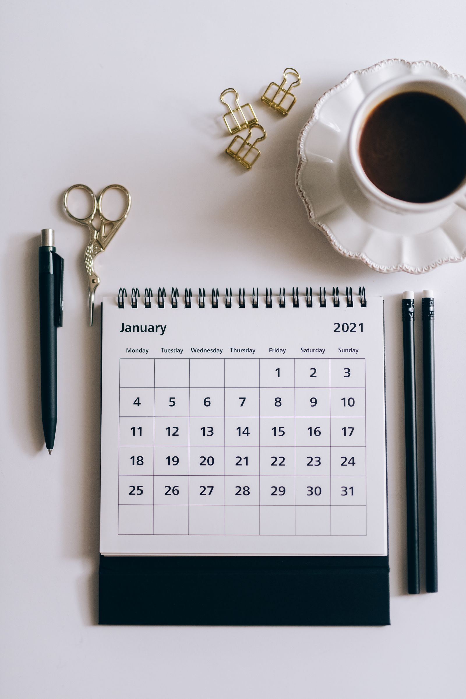 A notebook and calendar laid out for an annual small business financial planning session
