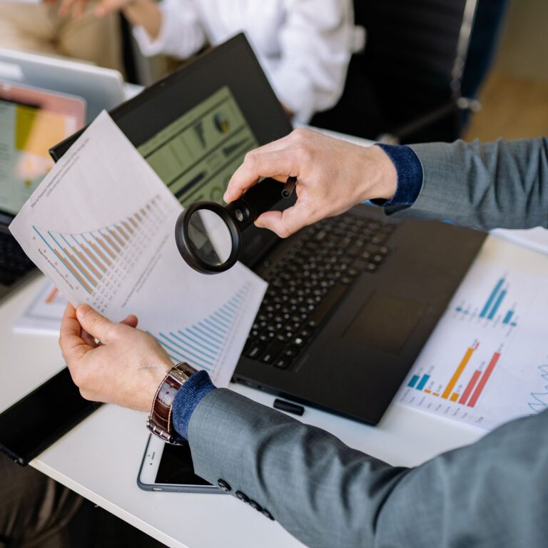 A document being checked closely with a magnifying glass during a banking fee audit